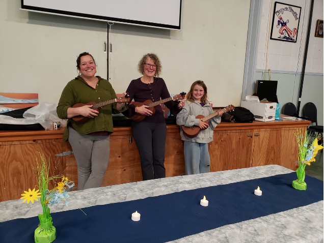 2 Women and 1 child playing ukuleles